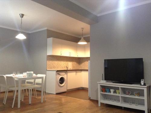 a living room with a table and a tv and a kitchen at Apartment Sredetz in Sofia