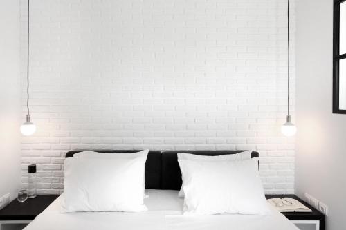 a white bedroom with a bed with two white pillows at Athens View Loft - 03 in Athens