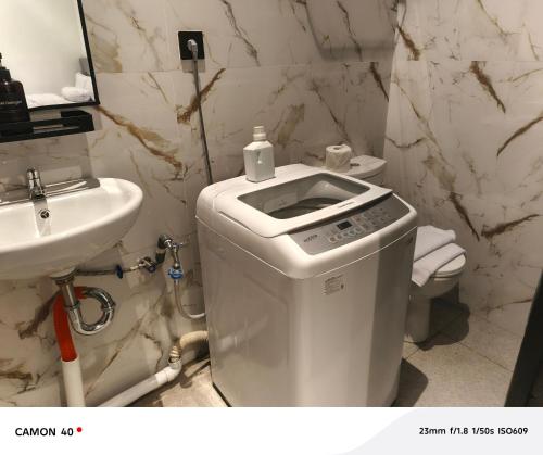 a white bathroom with a toilet and a sink at CBD Studio Loft 1B at City Center! in Medan