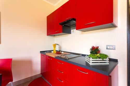 a kitchen with red cabinets and a sink at Easy Space in Bientina