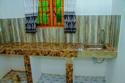 baño con lavabo y vidriera en Golden Eco Ayur Villa, en Dambulla