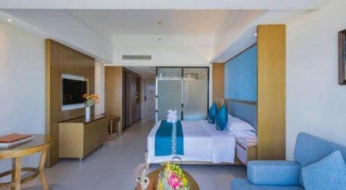 a hotel room with a bed and a desk at Da Peng Zhongzhou Hotel in Haikou