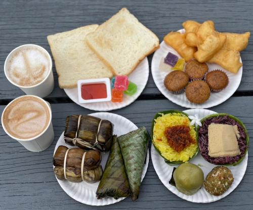 a table with four plates of food and two cups of coffee at Khao Rang Place in Phuket Town