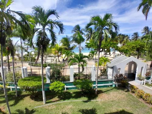 a house with palm trees and the ocean in the background at Beachview 1 Bedroom 4 at Sandcastles in Ocho Rios