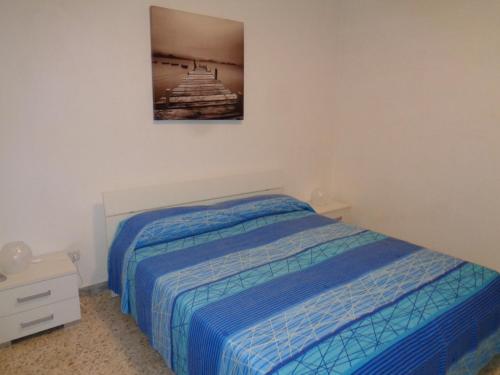 a bedroom with a bed and a picture on the wall at Villa Bocca del Pozzo in Gagliano del Capo