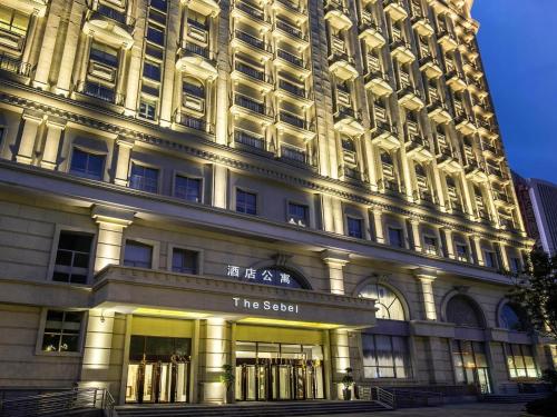 a large white building with a sign on it at The Sebel Xining-Managed By Sofitel in Xining