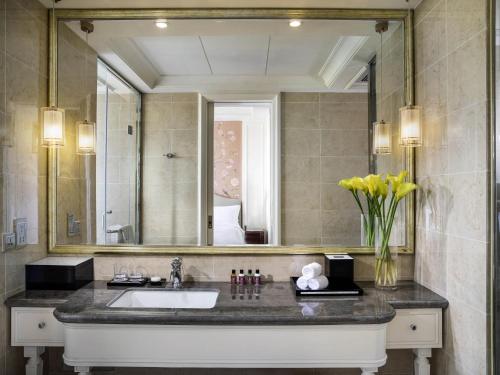 a bathroom with a sink and a large mirror at The Sebel Xining-Managed By Sofitel in Xining