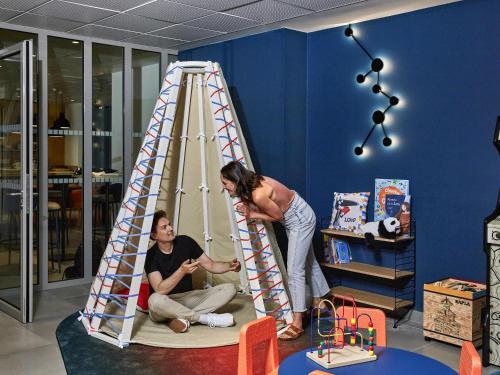 two women playing with a ladder in a room at Aparthotel Adagio Access La Défense Puteaux in Puteaux