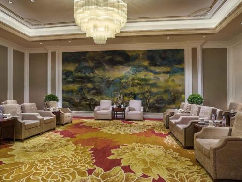 a large room with chairs and a large painting at The Sebel Xining-Managed By Sofitel in Xining