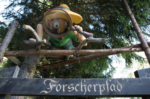 a figurine of a man with a hat sitting on a sign at Burgstadl Aparthotel & Restaurant in Ladis