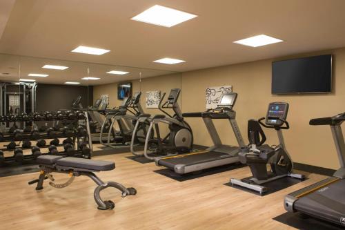 a gym with a bunch of exercise bikes and a flat screen tv at AC Hotel Kansas City Plaza in Kansas City