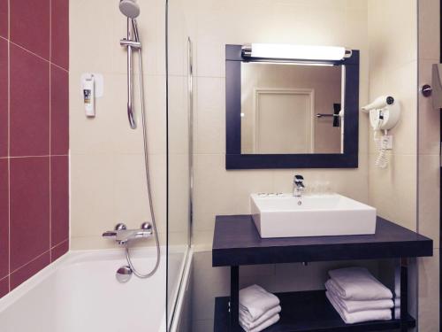 a bathroom with a sink and a shower at Mercure Maurepas Saint Quentin in Maurepas