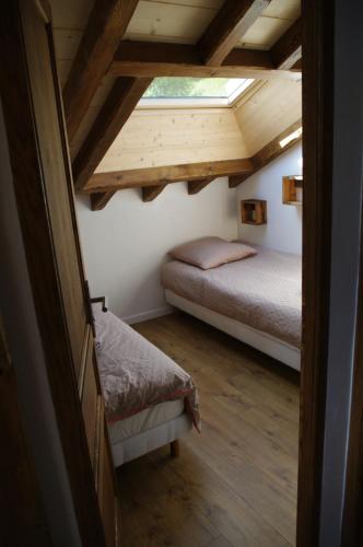 a bedroom with a bed and a window at Petit Chalet Vieux Bois in Bozel