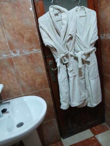 a bathroom with a sink and a toilet and towels at Résidence Kawtar Meknès in Meknès