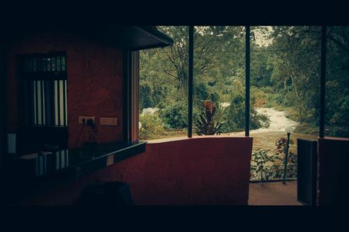 a window of a building with a view of a road at Ela Ecoland Nature Retreat in Munnar