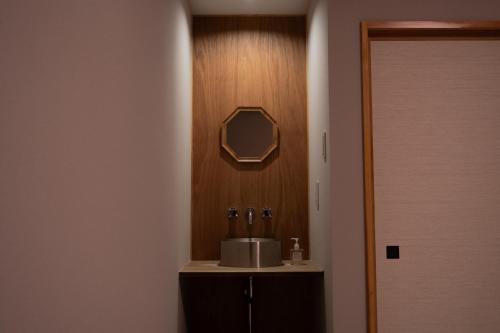 a bathroom with a sink and a mirror on the wall at Irifune in Katsuyama
