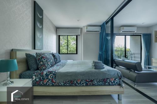 un dormitorio con una cama y un sofá en Cozy apartment by the sea F410, en Nai Yang Beach