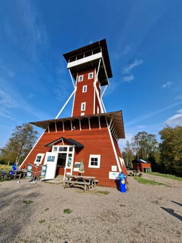 a red barn with a roof on top of it at Stuga Gasstorp Wifi in Hova