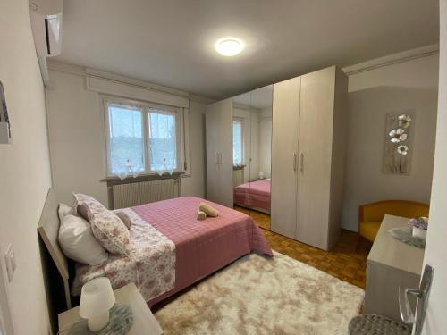 a bedroom with a bed with a pink blanket at Stay Friuli Pordenone 3 Camere in Pordenone