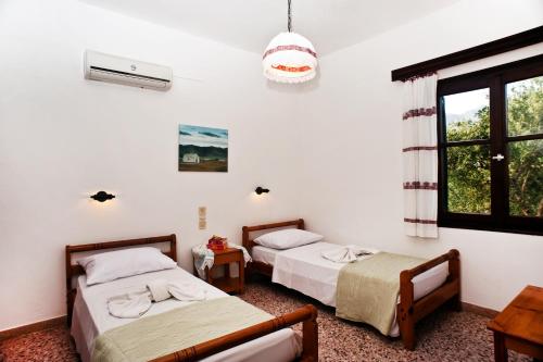 a room with two beds and a window at Dolphin Apartments in Frangokastello