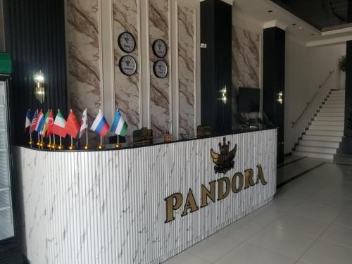 a lobby with a pandolis sign and clocks on the wall at Хотел Пандора in Muruntau