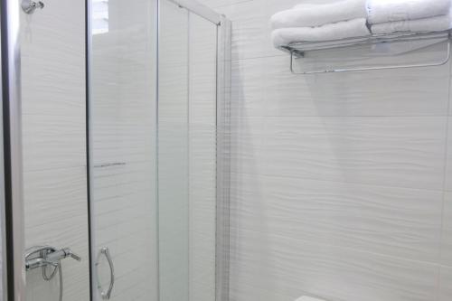 W łazience znajduje się przeszklona kabina prysznicowa z ręcznikami. w obiekcie Lina's Apartments w mieście Parga