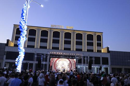 a large crowd of people in front of a building at Хотел Пандора in Muruntau