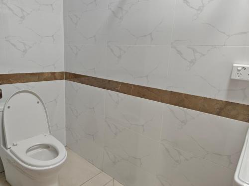 a bathroom with a white toilet in a room at Wanderlight in Nadi