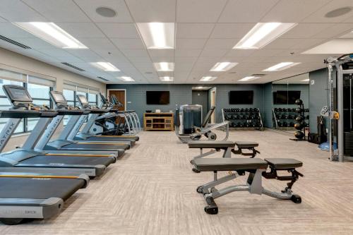 a gym with a row of treadmills and machines at Marriott Dallas Allen Hotel & Convention Center in Allen