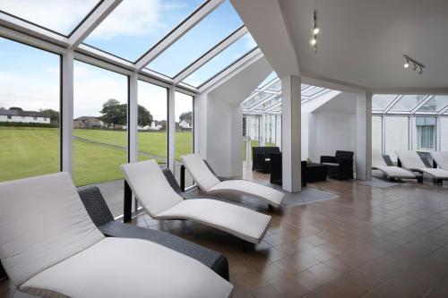 a waiting room with white chairs and windows at Delta Hotels by Marriott Edinburgh in Edinburgh