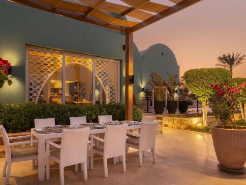 a dining table and chairs on a patio at Novotel Marsa Alam Beach Resort in Quseir