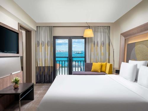 a hotel room with a large bed and a balcony at Novotel Istanbul Bosphorus Hotel in Istanbul