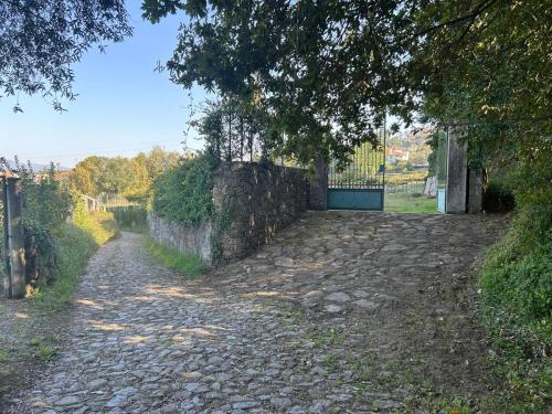 a cobblestone road with a gate and a fence at Casa dos Macieis - Entire Main House, Entire Guesthouse or Separate Wing of Main House - Camino Santiago direct access & Optional Agritourism in Facha
