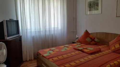 a small bedroom with a bed and a television at Black Sea Coast Apartment in Constanţa