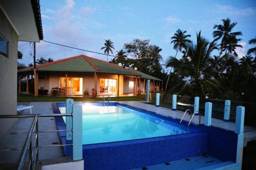 a house with a swimming pool in front of a house at The New Hilltop Villa in Galle