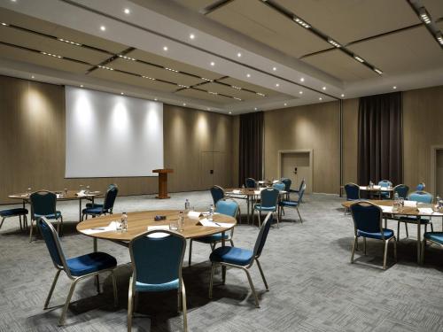 a conference room with tables and chairs and a projection screen at Novotel Istanbul Bosphorus Hotel in Istanbul
