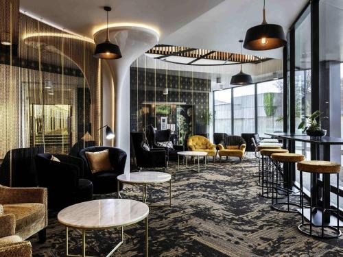 a lobby with tables and couches and chairs at Novotel New Plymouth Taranaki in New Plymouth
