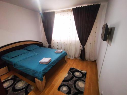 a small bedroom with a bed and a window at Ramona&Alin in Craiova
