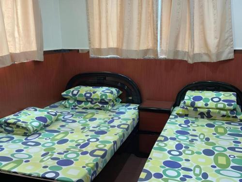 two beds sitting next to each other in a room at New Mong Kok Guest House in Hong Kong
