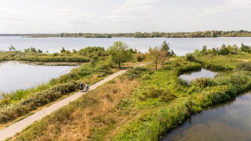a person riding a bike on a path next to a river at Loft 8 Linden in Groot-Linden