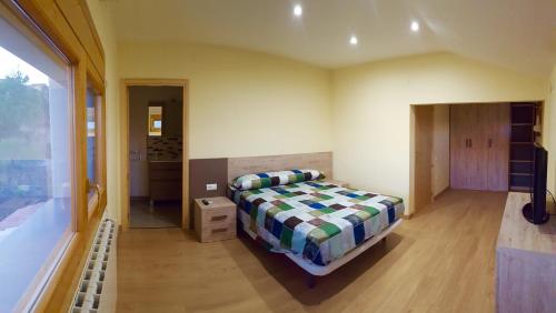 a bedroom with a bed and a large window at CASA LA FÀBRICA in Horta de San Joan