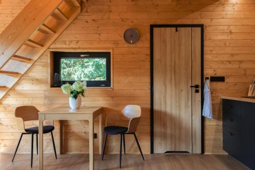 a room with a table and chairs and a door at Chata Cedrus in Hradištko