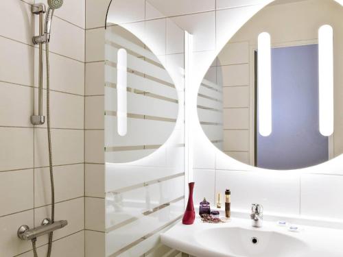 a bathroom with a sink and a mirror at ibis budget Grigny Centre in Grigny