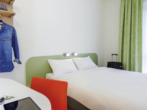 a bedroom with a bed and a table and a chair at Ibis Budget Bamberg in Bamberg