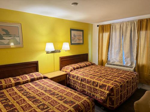 een hotelkamer met twee bedden en een raam bij Economy Inn Ontario in Ontario