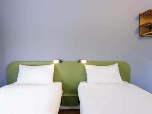 two beds sitting next to each other in a room at Ibis Budget Bamberg in Bamberg