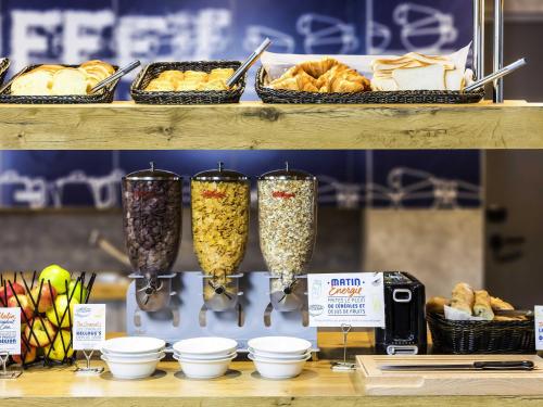 a shelf with three glasses of food and pastries at Ibis Budget Bamberg in Bamberg