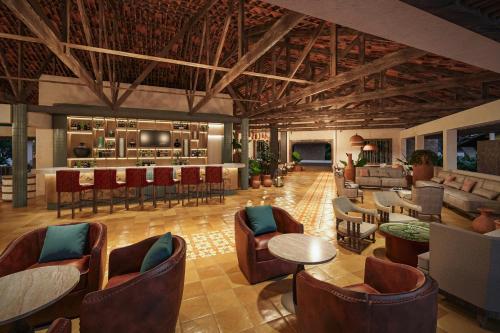 a lobby with chairs and tables and a bar at Santa Lucia Jungle Hacienda, Autograph Collection in Tarcoles
