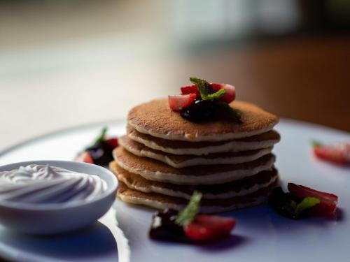 a stack of pancakes with strawberries on a plate at Mercure Hyderabad KCP Banjara Hills, An Accor Hotel in Hyderabad