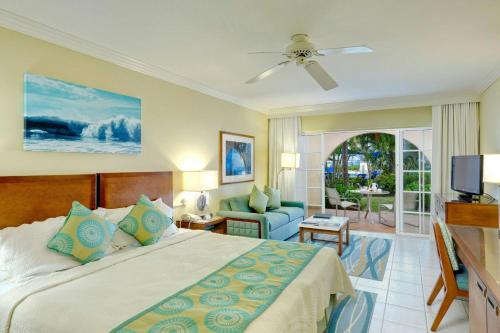 a bedroom with a bed and a living room at Turtle Beach, a Tribute Portfolio All Inclusive Hotel in Christ Church